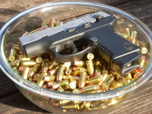 700-rounds-in-a-glass-bowl-with-a-handgun-resting-on-top